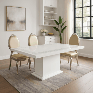 Agra dining table with real marble top and elegant carved pedestal base, paired with gold dining chairs in a luxurious kitchen interior.