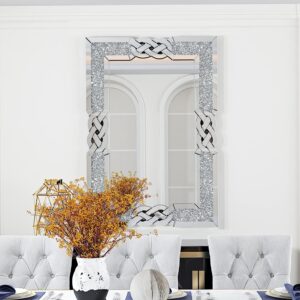 Vertical crushed diamond silver wall mirror with decorative knot accents, styled above a black and gold console in a luxury dining room.